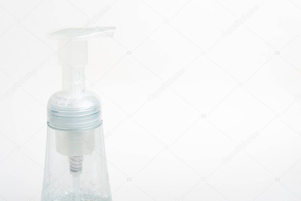 A close-up image of the translucent top pump and bottle of a foam soap plastic dispenser set on a white background.