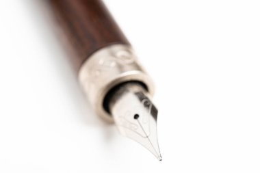 Tahta fıçının yakın çekim görüntüsü ve düz beyaz arka planda klasik bir dolmakalem setinin yazı ucu..