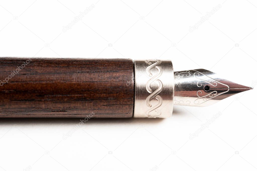 A close-up product shot of the wooden barrel and writing tip of a classic fountain pen set on plain white background.