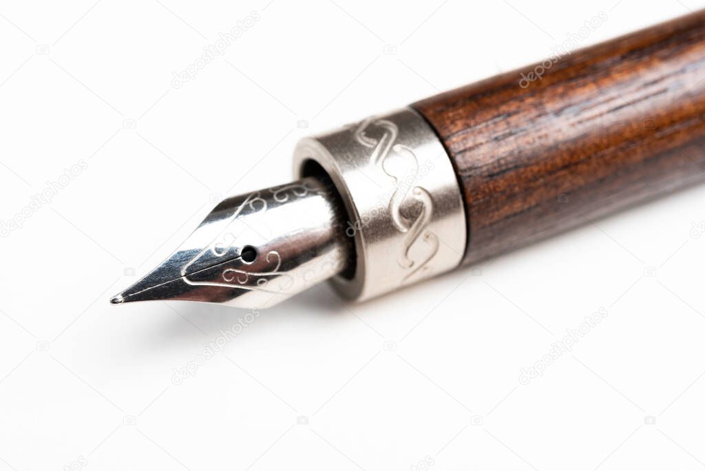 A close-up product shot of the wooden barrel and writing tip of a classic fountain pen set on plain white background.