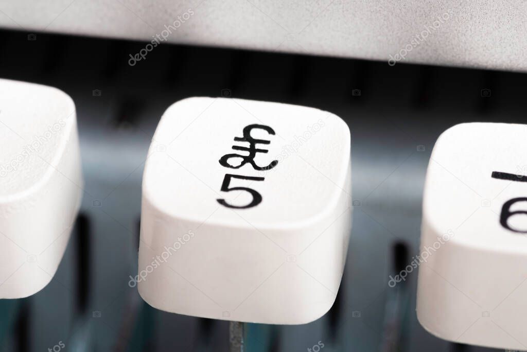 An extreme close-up or macro shot of a plastic keyboard key from a manual typewriter with shallow depth of field and selective focus.