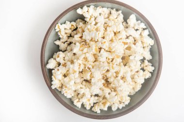 Beyaz arka planda seramik kasede patlamış mısır..