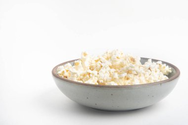 Beyaz arka planda seramik kasede patlamış mısır..