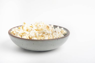 Beyaz arka planda seramik kasede patlamış mısır..