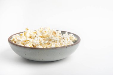 Beyaz arka planda seramik kasede patlamış mısır..