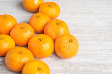 Bir grup taze portakal, beyaz desenli ahşap panoda ustalıkla düzenlenmiş..