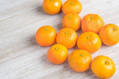 Bir grup taze portakal, beyaz desenli ahşap panoda ustalıkla düzenlenmiş..