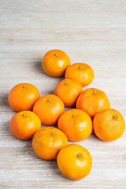 Bir grup taze portakal, beyaz desenli ahşap panoda ustalıkla düzenlenmiş..