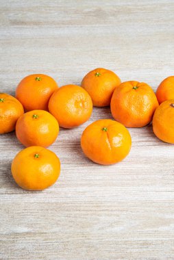 Bir grup taze portakal, beyaz desenli ahşap panoda ustalıkla düzenlenmiş..