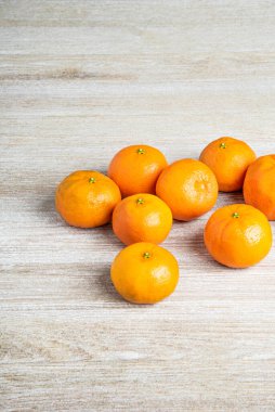 Bir grup taze portakal, beyaz desenli ahşap panoda ustalıkla düzenlenmiş..