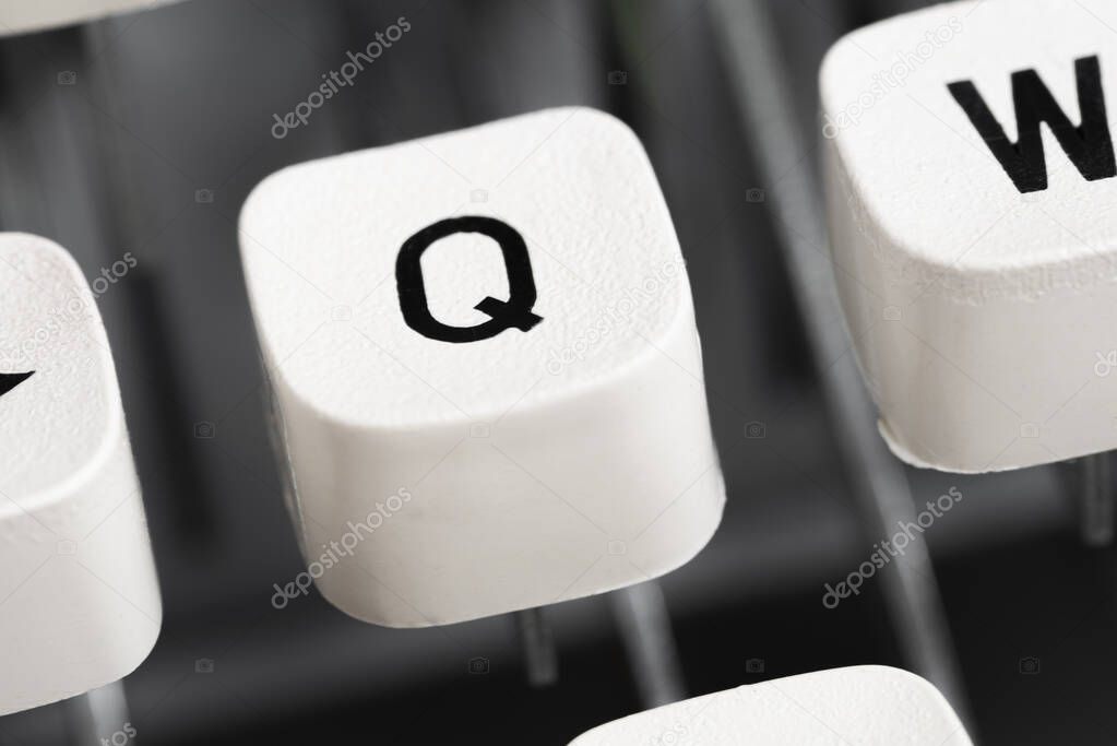 An extreme close-up or macro shot of a plastic keyboard key cap from a manual typewriter with shallow depth of field and selective focus.