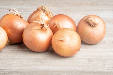 Bir demet taze, otantik güney yetiştirilmiş soğan ustalıkla beyaz boyalı bir ahşap panoya yerleştirilmiş..