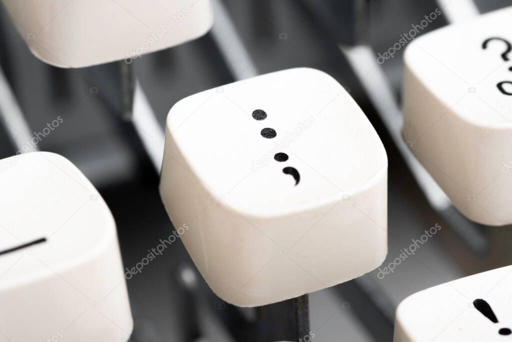 An extreme close-up or macro shot of a white plastic keyboard key cap from a manual typewriter with shallow depth of field and selective focus.