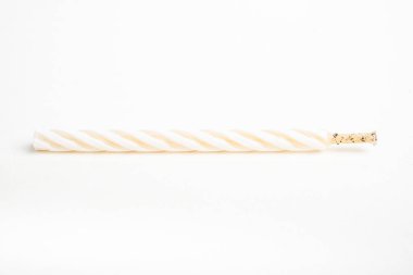 Işıksız bir tam doğum günü pastasının makro çekimi. Beyaz arka planda tek bir dekoratif renk girdaplı mum..