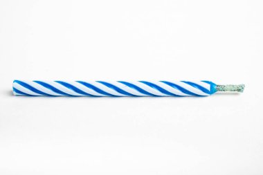 A macro shot of an unlit full birthday cake topping candle with single decorative color swirl set on a plain white background. clipart