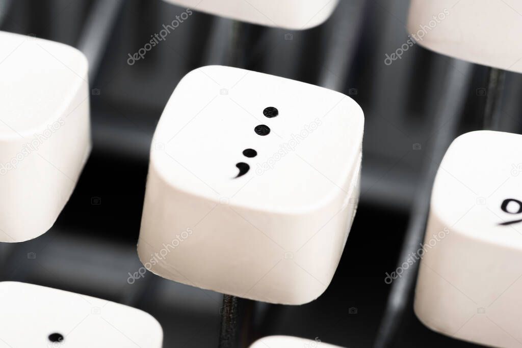 An extreme close-up or macro shot of a white plastic keyboard key cap from a manual typewriter with shallow depth of field and selective focus.