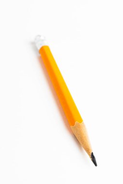 Sivri uçlu sarı-turuncu altıgen kalem koçanı, beyaz kağıt üzerine seçici odaklı yakın çekim ya da makro çekim..