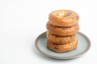Seramik tabakta sade beyaz zemin üzerine seramik simit serpiştirilmiş 4 'lük bir yığın.. 