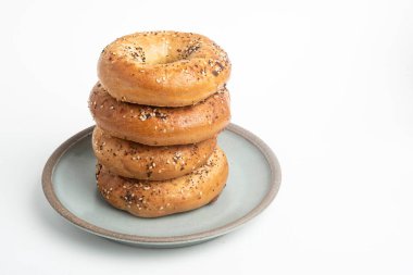 Seramik tabakta sade beyaz zemin üzerine seramik simit serpiştirilmiş 4 'lük bir yığın.. 