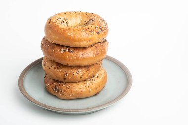 Seramik tabakta sade beyaz zemin üzerine seramik simit serpiştirilmiş 4 'lük bir yığın.. 