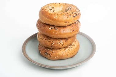 Seramik tabakta sade beyaz zemin üzerine seramik simit serpiştirilmiş 4 'lük bir yığın.. 