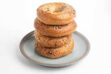 Seramik tabakta sade beyaz zemin üzerine seramik simit serpiştirilmiş 4 'lük bir yığın.. 