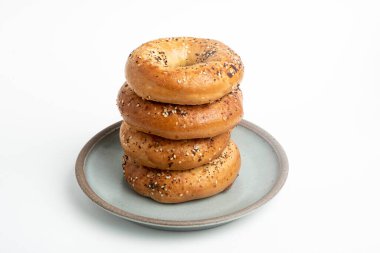 Seramik tabakta sade beyaz zemin üzerine seramik simit serpiştirilmiş 4 'lük bir yığın.. 