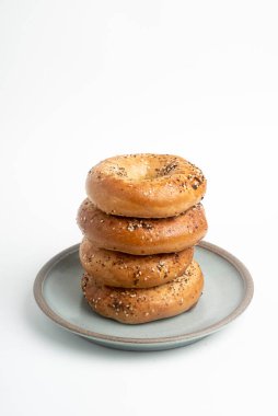 Seramik tabakta sade beyaz zemin üzerine seramik simit serpiştirilmiş 4 'lük bir yığın.. 