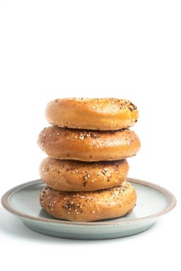 Seramik tabakta sade beyaz zemin üzerine seramik simit serpiştirilmiş 4 'lük bir yığın.. 