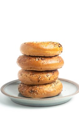 Seramik tabakta sade beyaz zemin üzerine seramik simit serpiştirilmiş 4 'lük bir yığın.. 