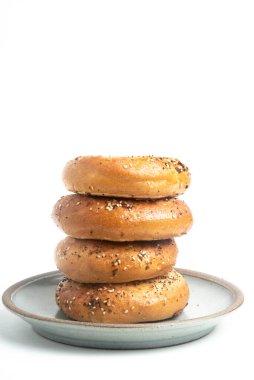 Seramik tabakta sade beyaz zemin üzerine seramik simit serpiştirilmiş 4 'lük bir yığın.. 