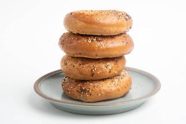 Seramik tabakta sade beyaz zemin üzerine seramik simit serpiştirilmiş 4 'lük bir yığın.. 