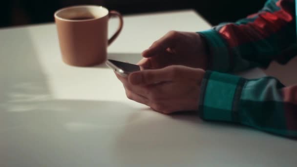 Homem Senta Manhã Cedo Uma Mesa Com Smartphone Mão — Vídeo de Stock