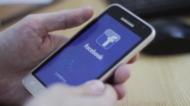 Yaroslavl / Russia - April 19 2019: The Facebook application takes a very long time to load. Some trouble with Facebook app. Smartphone in man's hand
