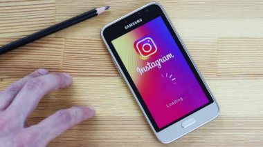 Yaroslavl / Russia - April 19 2019: The Instagram application takes a very long time to load. The man at the table is nervously waiting for the load of the Instagram app