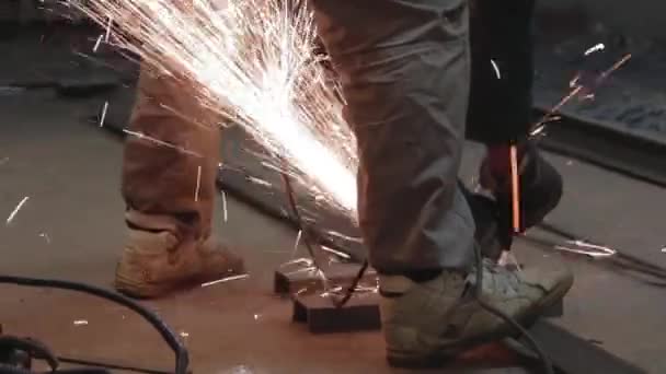 男はガレージで円形の鋸を働く 熱い金属からの火花のハエ 男は鋼鉄の上で働いた — ストック動画