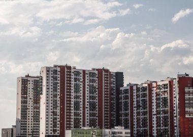 Modern, apartman. Bina alışılmadık bir mimariye sahiptir. Sahilde ev yelkeni. Güzel boyama. Mavi gökyüzüne karşı bina.