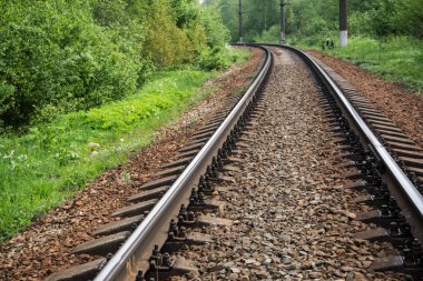 Ormanda demiryolu. Raylar ve uyuyanlar ezilmiş granit üzerinde. Bahar gündür..