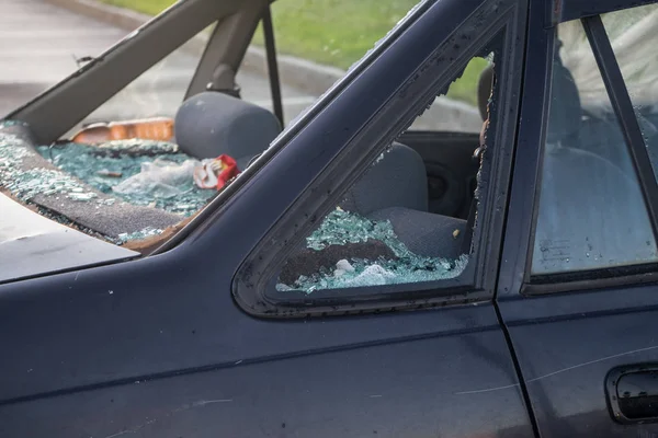 Otoparkta binek araba. Hırsızlar camı kırdı ve kulübeden değerli eşyaları çaldı. Bahar. Gün.