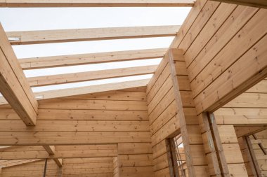 Ahşap bir evin detayları. Tavan kirişleri ve yapıştırılmış lamine ahşap evin duvarları. Yaz günü.