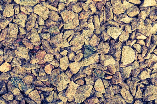 Abstract background from crushed granite. Stone, crushed into small parts for construction work. Summer. Day