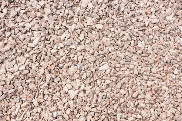 Abstract background from crushed granite. Stone, crushed into small parts for construction work. Summer. Day