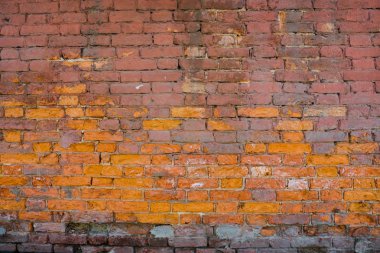 Eski kırmızı tuğlanın arka planı. Alçısız eski evin duvarı. Tuğla dayanıklı bir malzemedir, ancak alçı koruyucu bir tabaka olmadan çöker. Sonra bütün duvar çöker..
