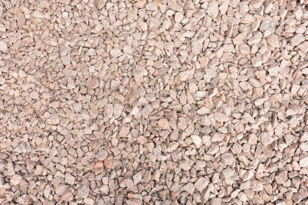 Abstract background from crushed granite. Stone, crushed into small parts for construction work. Summer. Day