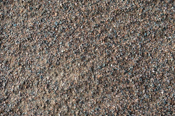 Abstract background from crushed granite. Stone, crushed into small parts for construction work. Summer. Day