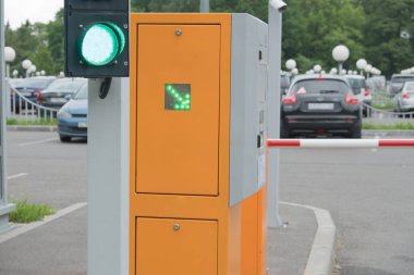 Otoparkta otomatik bariyer. Çözme, yeşil ışık semafor. Yeşil ok. Yaz, bulutlu gün.