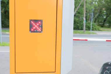 Otoparkta otomatik bariyer. Ateşi yasaklamak. Kızıl Led haçı. Yaz, bulutlu gün.