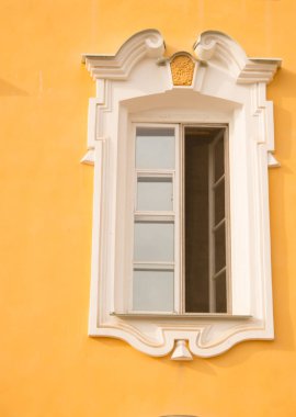 Eski bir binanın penceresi, saray. Çerçeve Barok tarzında sıva yapılır. Duvarların sarı arka plan üzerinde beyaz keten (ocher). Büyük Peterhof Sarayı. Yaz güneşli bir gündür..