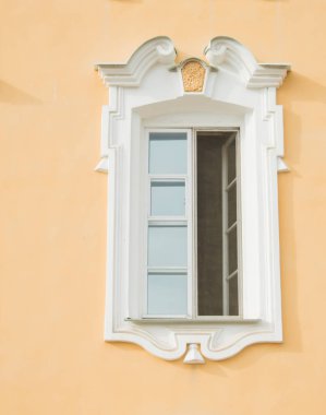 Eski bir binanın penceresi, saray. Çerçeve Barok tarzında sıva yapılır. Duvarların sarı arka plan üzerinde beyaz keten (ocher). Büyük Peterhof Sarayı. Yaz güneşli bir gündür..