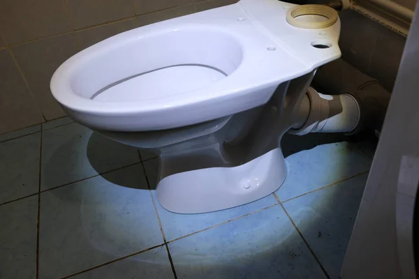 配管工が新しいトイレを設置しています バスルームに新しい白い磁器のトイレ — ストック写真
